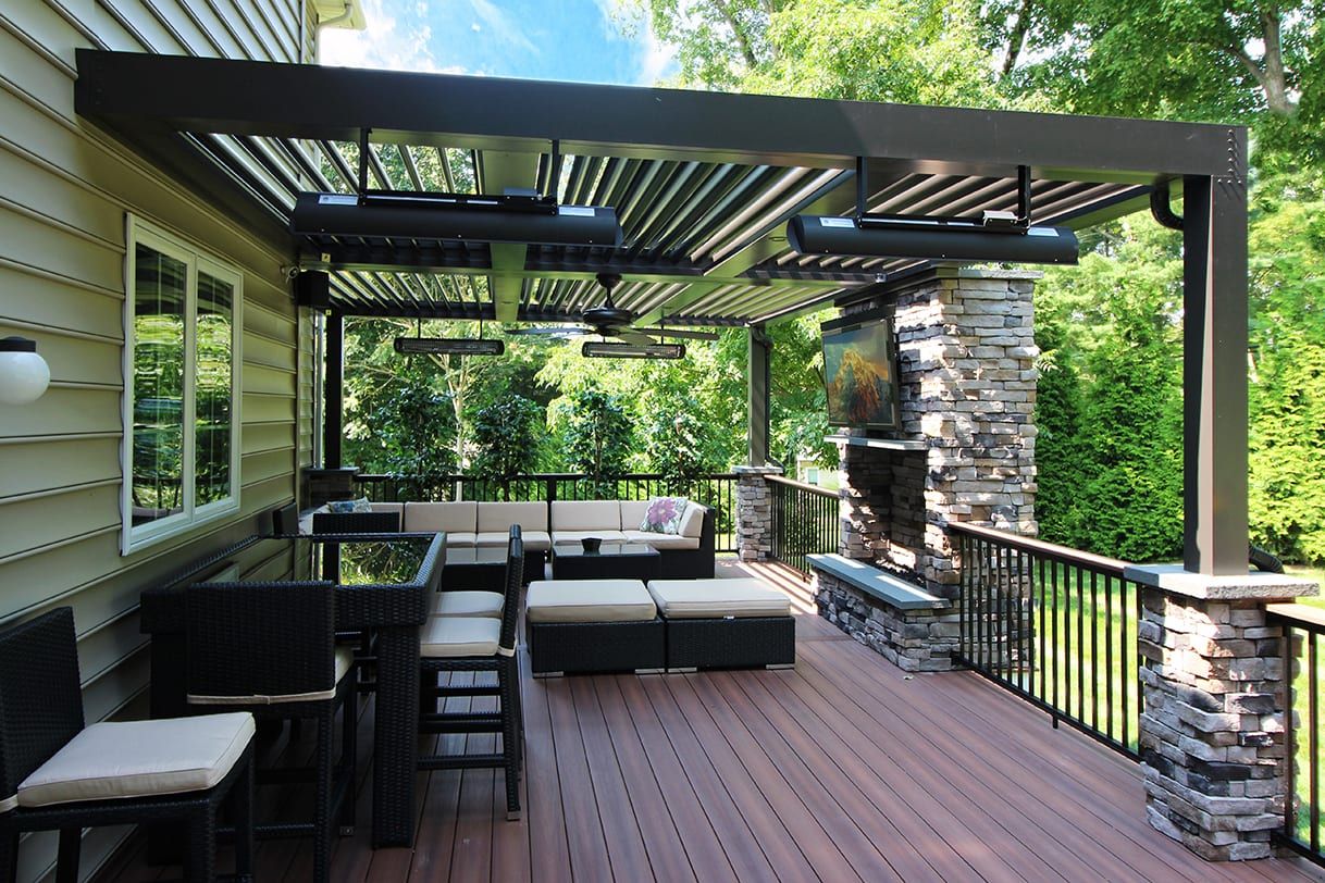 Covered composite deck with louvered pergola and lounge seating